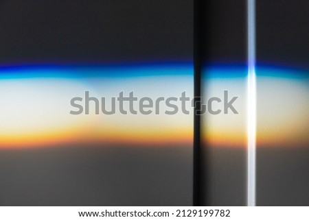 Beam of sunlight with spectrum colors goes over white wall, physical refraction effect. Abstract close up photo background