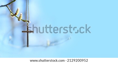pussy willow branch and christianity cross on abstract blue natural background. Easter holiday, Orthodox palm Sunday. symbol of Christianity, faith in God, prayer. spring season. banner. copy space