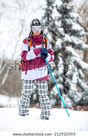 Winter tourism, winter fun, snow, winter travel - young woman traveling hiking in stormy snow weather. Active outdoor sport lifestyle