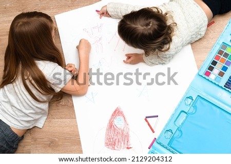 Little boys drawing a picture on the floor in his room, top view. Children's art , home schooling , montessori and creativeness concept. High quality photo.