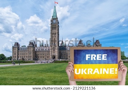 Free Ukraine Protest concept, male holding a blank protest sign in front of Canadian parliament in Ottawa