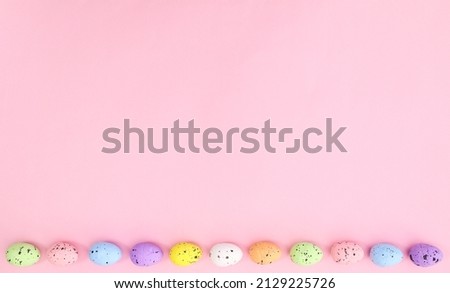 Pastel Easter eggs on bright pink background neatly ordered. Spring holidays copy space concept.