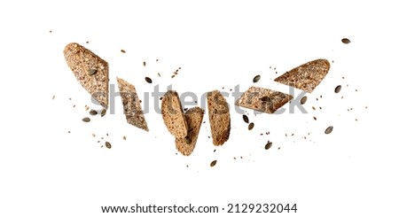 Sliced fresh baked loaf whole grain wheat baguette bread with pumpkin, sunflower, poppies and flax seeds flying isolated on white background. Healthy pastry food Royalty-Free Stock Photo #2129232044