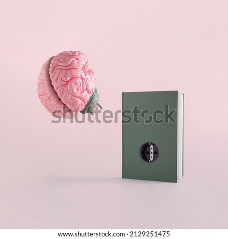 Human brain and dark green book with socket on isolated pastel pink background. Minimal abstract retro concept of school, culture, intelligence, reading or education. Charger for brain idea. Royalty-Free Stock Photo #2129251475