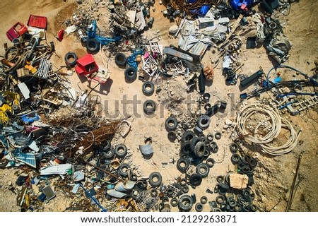 Aerial view of car tyres, metal rods and other construction debris. Dump of various waste. Top down aerial view to scrap metal and tires at landfill Royalty-Free Stock Photo #2129263871
