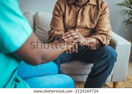 Nurse holding hand of senior man in rest home. Doctor helping old patient with Alzheimer's disease. Shot of a caregiver helping a senior man. Care Worker Helping Senior Man