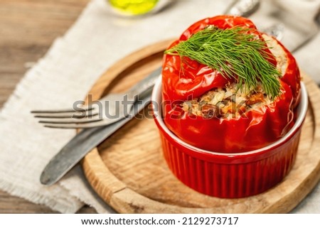 Homemade meat and rice stuffed bell peppers. Olive oil, sauce, cutlery. Traditional healthy food, vintage wooden background, close up, selective focus
