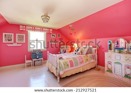 Beautiful girls room in bright pink color with carved wood bed and toys