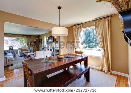 Soft beige dining room with massive wood table decorated with candles