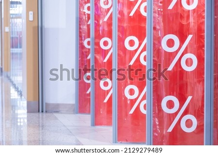 Shopping center. Red bright sale word banner on anti-thieft gate sensor at retail shopping mall entrance. Seasonal discount offer in store