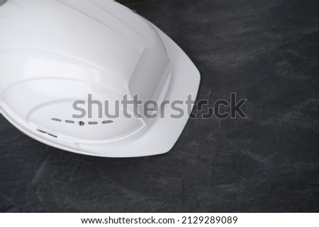 white hardhat, builder, architect helmet, work gloves on scaffolding, background of high buildings, protection inspecting at construction site for building renovation, civil engineering concept