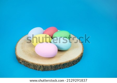Easter, plain, multi-colored eggs on a hemp plate on a blue background. The concept of holiday, religion, customs, egg coloring . High quality photo