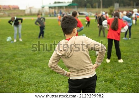 Schoolboy does gymnastics in park. Sports activity for children. Health Day in Russia. Child trains in summer.