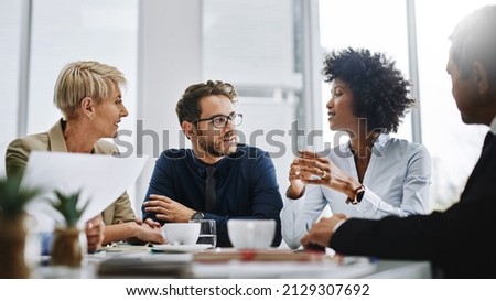 Give us difficult and well show you easy. Shot of a group of businesspeople sitting together in a meeting. Royalty-Free Stock Photo #2129307692