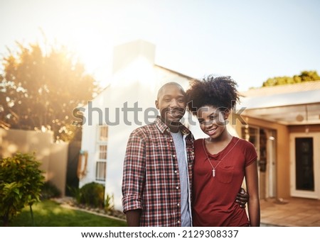 Proud first-time homeowners. Portrait of a young couple standing outside in front of their new house. Royalty-Free Stock Photo #2129308337