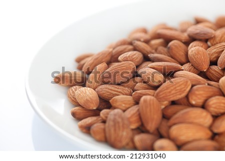 Raw almonds in a plate. Shallow depth of field. Close-up.