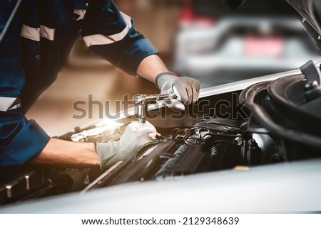 Car care maintenance and servicing, Close-up hand technician auto mechanic using the wrench to repairing change spare part car engine problem and car insurance service support. Royalty-Free Stock Photo #2129348639