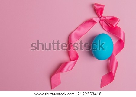 bow and easter blue egg on pink background