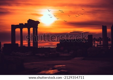 Silhouette of Apollon Temple in Side antique city, temple of Apollon ancient ruins at sunset. Greek ancient historical antique Side Antalya Turkey. Royalty-Free Stock Photo #2129354711