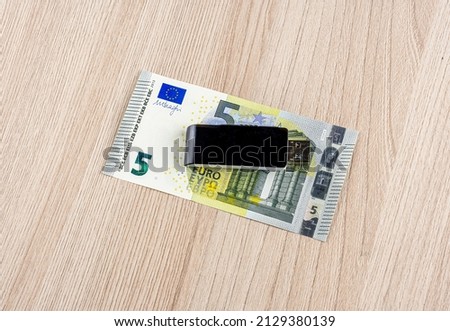 memory usb flash drive on a euro banknote on a wooden background close up, information security concept
