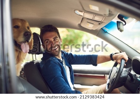 You comfy back there. Cropped shot of a handsome young man taking a drive with his dog in the backseat. Royalty-Free Stock Photo #2129383424
