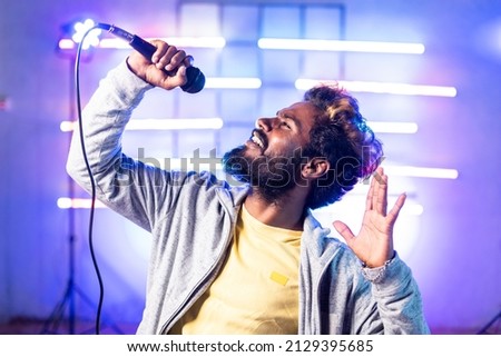 joyful musician dancing by signing song on mic - concept of entertainment, hip hop music and nightlife