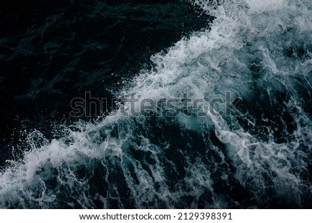 Abstract blue ocean water with white foam background. Sea waves texture.Selective focus.