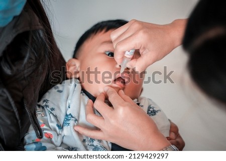 Nurse making infant oral vaccination against rotavirus infection. Children health care and disease prevention. Royalty-Free Stock Photo #2129429297