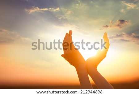 hands holding the sun at dawn Royalty-Free Stock Photo #212944696