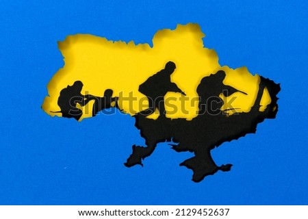 War in Ukraine, illustration photo, Ukraine colors blue and yellow. Silhouette of Ukraine map, black tanks in the background. Conflict between Russia and Ukraine Royalty-Free Stock Photo #2129452637