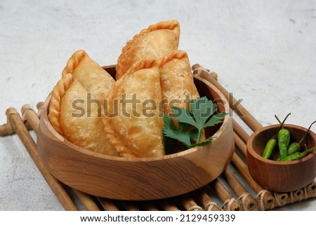 Curry puff (kari pap )  or Pastel Goreng is Pastry Popular in Indonesia.
fried pastry with filling of sautéed vegetable , chicken and boiled egg. accompanied with  sauce or raw chilli pepper Royalty-Free Stock Photo #2129459339