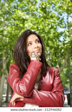 pretty brunette woman with red leather jacket thinking 