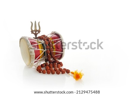 Shivaratri background with Shivas trident and Pellet Drum Damroo musical instrument . Hindu festival Maha Shivratri Royalty-Free Stock Photo #2129475488