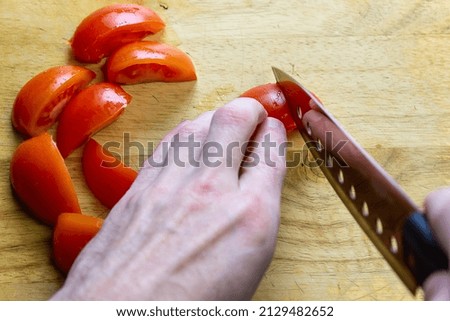 a person cuts tomatoes on a board