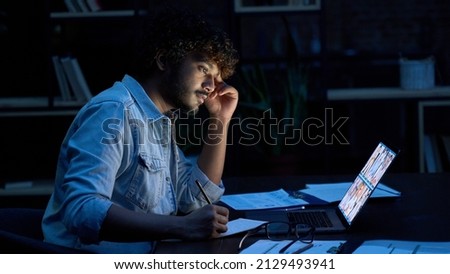 Focused indian latin business man having remote video call conference team meeting working online by distant videocall web chat late at night at home in dark office using laptop computer. Royalty-Free Stock Photo #2129493941