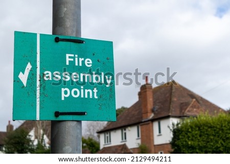 Fire assembly point sign attached to a lamp post on a suburban street