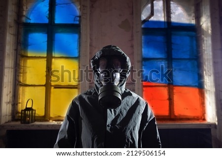 Concept of Russian forces capturing the Cernobyl power plant. Person with gas mask and the Ukrain and Russian flag Royalty-Free Stock Photo #2129506154