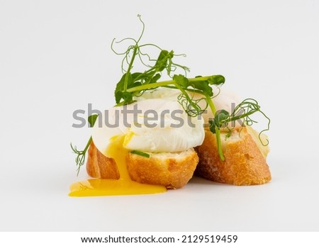 Poached egg on bread on white background. Tasty egg  on white background.  Royalty-Free Stock Photo #2129519459