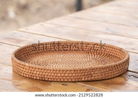 round rattan basket isolated on wooden background Royalty-Free Stock Photo #2129522828