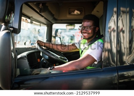 Young handsome African American man working in towing service and driving his truck. Royalty-Free Stock Photo #2129537999