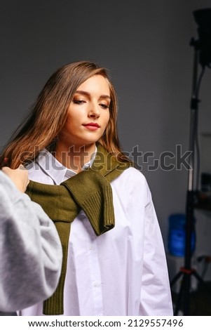Beautiful young girl with long hair and closed eyes in a beauty salon while preparing for a photo shoot.