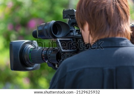 Video camera operator working with his equipment. video cinema production. Covering an event with a video camera. Professional video man hand holding camera operator camcorder working.