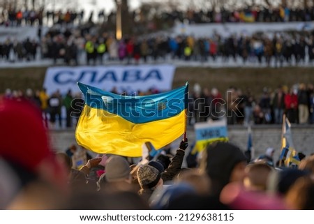 activist or protester holding a Ukrainian flag at a public demonstration or meeting supporting Ukraine in Estonia, Tallinn