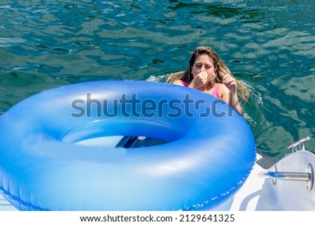 Woman in a bikini in the sea water with a buoy. Salvador Bahia Brazil.