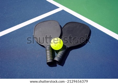 Pickleball Paddle and pickle ball of court.                          Royalty-Free Stock Photo #2129656379