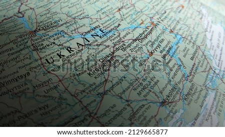 A close up fish eye view of the word Ukraine on a geographical map of the country. Nation of Ukraine in an atlas with text. Kyyiv or Kiev is also prominent.  Royalty-Free Stock Photo #2129665877