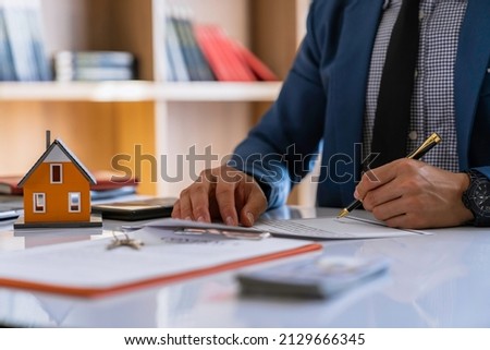 Real estate broker agent being analysis and making the decision a home estate loan to the customer to signing contract documents for realty purchase, Bank employees recommend mortgage loan approval.