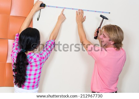 Couple chooses a place for a picture with the help of measuring tape