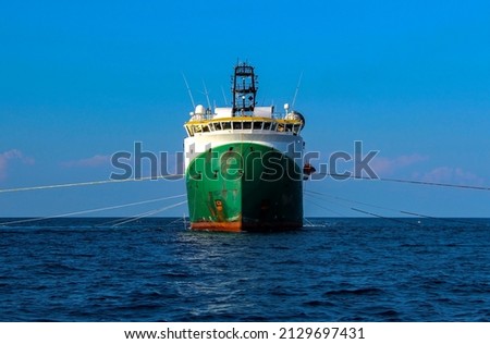 Seismic survey vessel seen from straight ahead with all towed in sea equipment deployed. Oil and gas exploration. Royalty-Free Stock Photo #2129697431