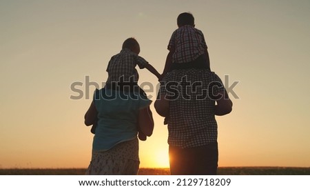 Happy childhood, family happiness concept. Silhouette of happy family, dad mom children walk together holding hands in summer park in sun. Family team, parents sons play at sunset. Father mother kids